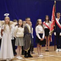 Grupa czwartoklasistów, którzy występowali w akademii stoi na tle dekoracji.