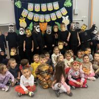 Dzieci świętują dzień zwierzaka, są ubrane na czarno a na twarzach mają maski różnych zwierząt.