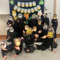 Dzieci świętują dzień zwierzaka, są ubrane na czarno a na twarzach mają maski różnych zwierząt.