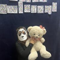 Dzieci świętują dzień zwierzaka, są ubrane na czarno a na twarzach mają maski różnych zwierząt.