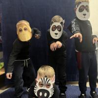 Dzieci świętują dzień zwierzaka, są ubrane na czarno a na twarzach mają maski różnych zwierząt.