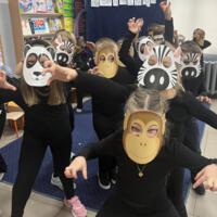 Dzieci świętują dzień zwierzaka, są ubrane na czarno a na twarzach mają maski różnych zwierząt.