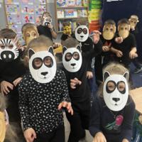 Dzieci świętują dzień zwierzaka, są ubrane na czarno a na twarzach mają maski różnych zwierząt.