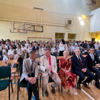 Na zdjęciach uczniowie szkoły, którzy oglądali akademię. Młodsze dzieci siedzą na ławeczkach. Starsze na krzesłach, najstarsi stoją z tyłu. Wszyscy są odświętnie ubrani.