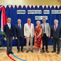 Zaproszeni gości z panią dyrektor i wicedyrektorem pozują do zdjęć pod napisem GMINNE ROZPOCZĘCIE ROKU SZKOLNEGO 2023-2024. 