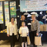 Dzieci które wygrały konkurs pozują do zdjęcia z organizatorami i dyrekcją.