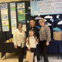 Dzieci które wygrały konkurs pozują do zdjęcia z organizatorami i dyrekcją.