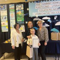 Dzieci które wygrały konkurs pozują do zdjęcia z organizatorami i dyrekcją.