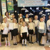 Dzieci które wygrały konkurs pozują do zdjęcia z organizatorami i dyrekcją.